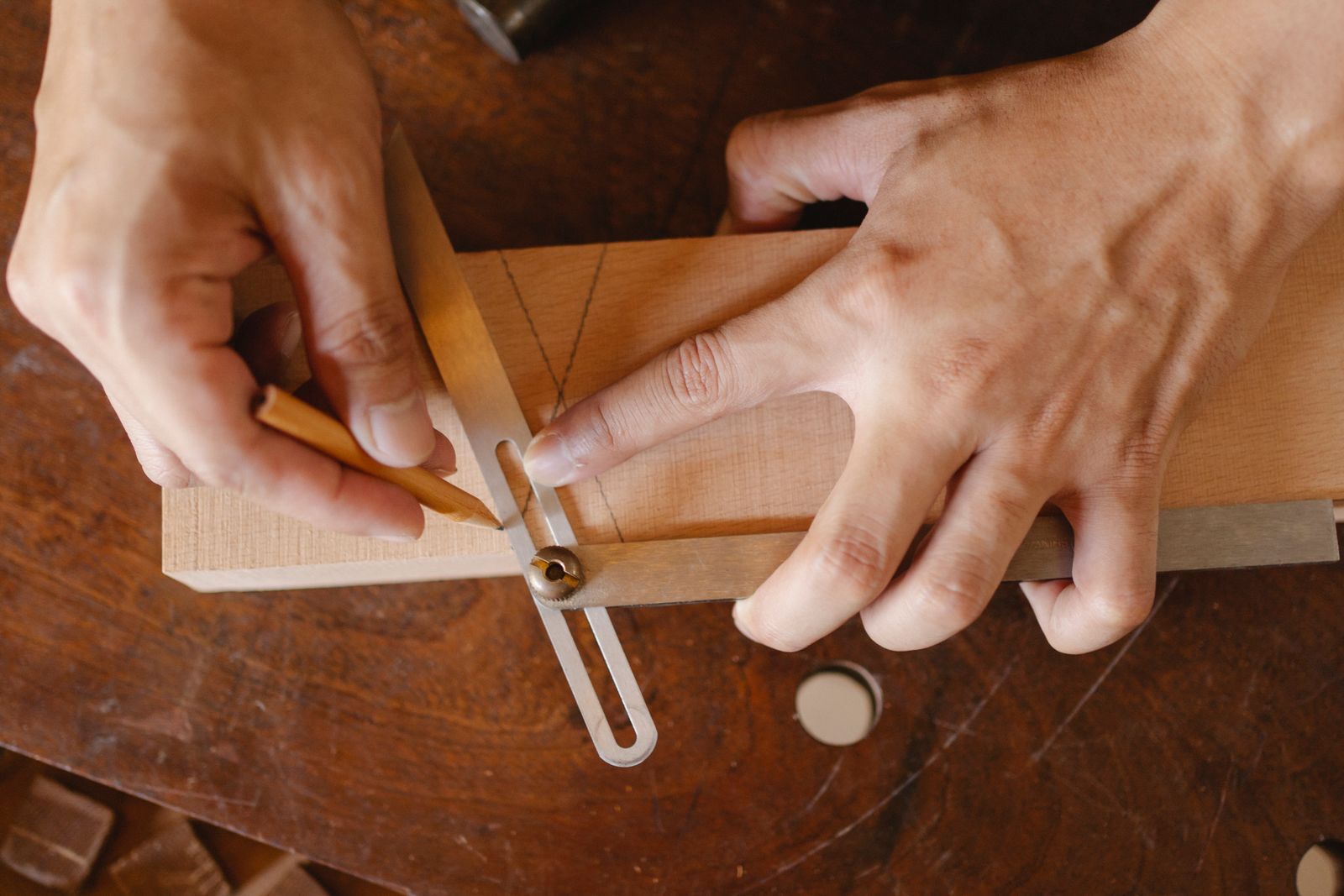 Craftsman marking mahogany with a brass bevel gauge