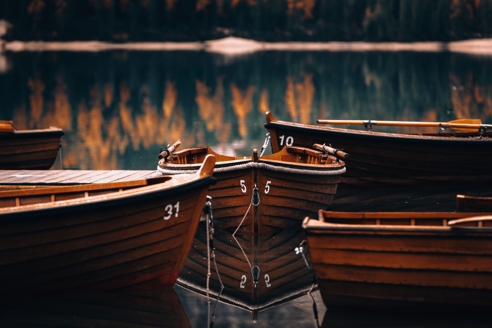 Wooden boats moored at dusk with warm reflections